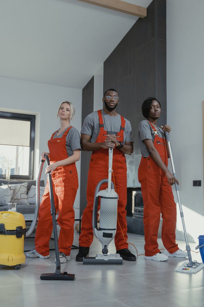 our-story Three cleaners in uniform with equipment in a modern home interior, showcasing teamwork and professionalism.